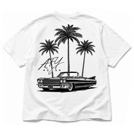 White short-sleeve T-shirt with a large black graphic print on the front featuring three palm trees, a vintage convertible car, and stylized text reading 'AFY USA'.